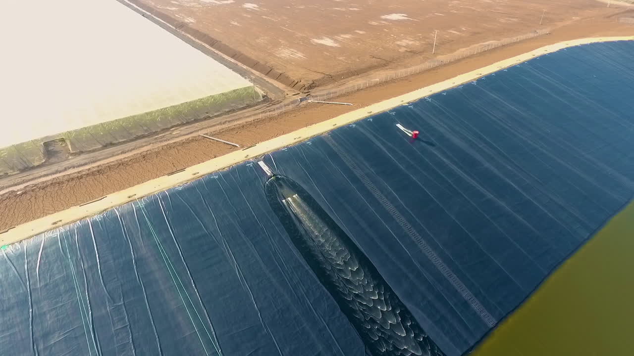 건설 과정의 일환으로 태양 전지 그릇에 추가되는 물의 하강 및 회전 드론 샷