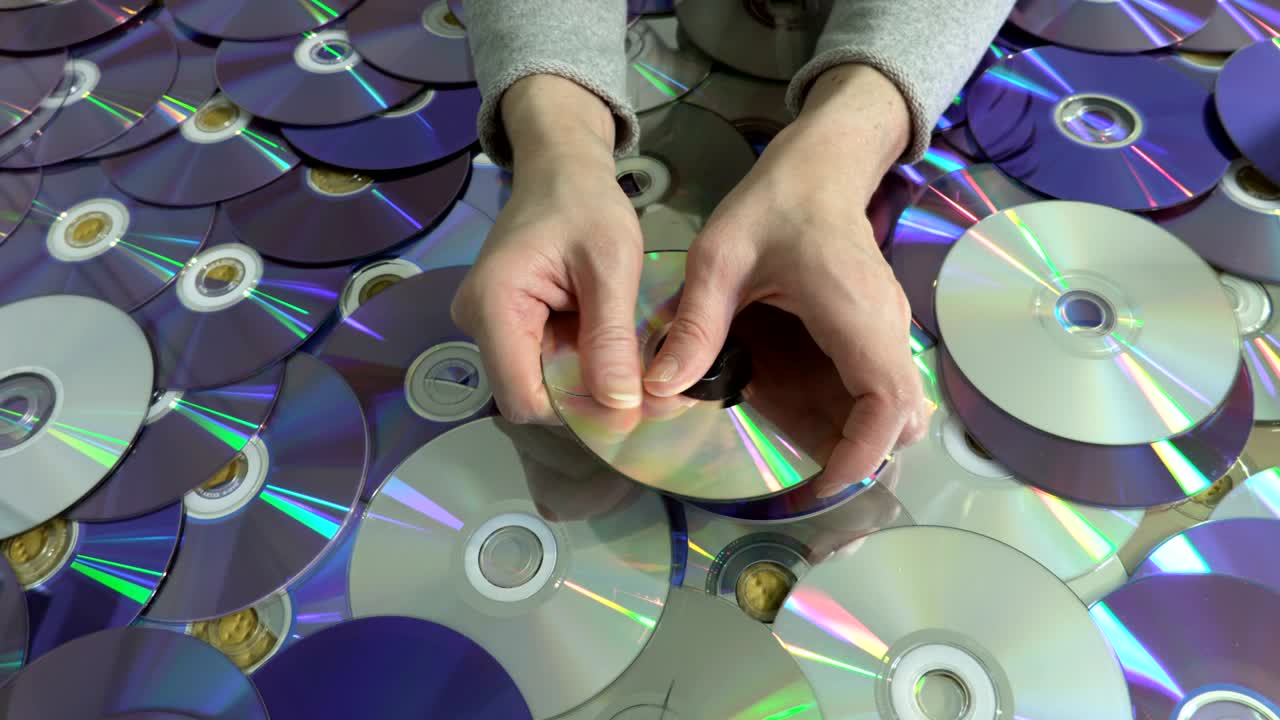 Woman holding damaged CD and DVD disc