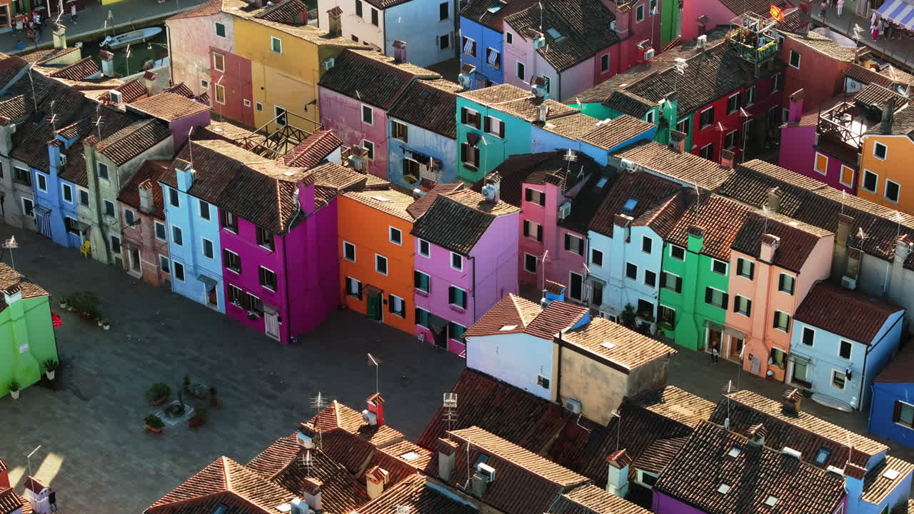 Aerial drone view of boats on the sides of a canal near the colourful houses of Burano, Italy