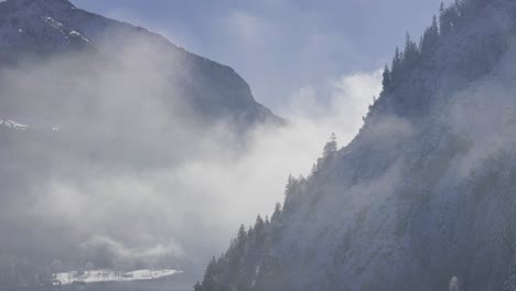 sideway flight at achensee tyrol with drone in winter at fog with clouds