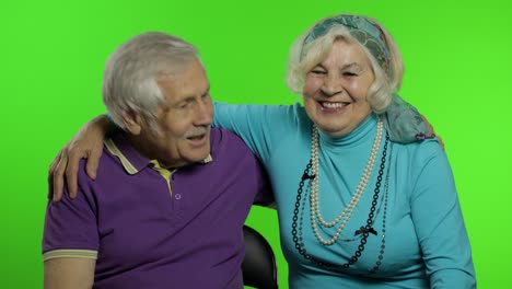 la pareja de ancianos maduros, los abuelos de la familia, disfrutan hablando, abrazándose.