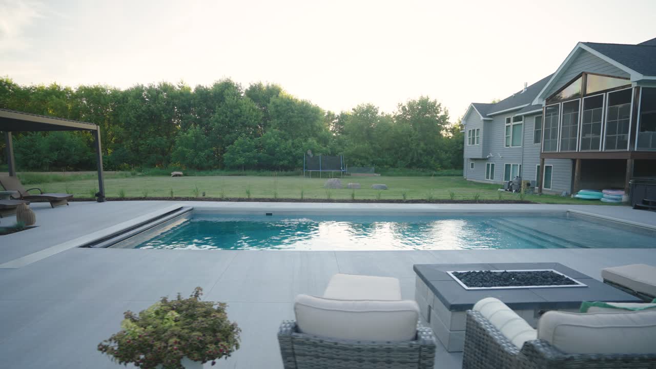 Clean daylight view of backyard pool, patio and pergola at suburban home