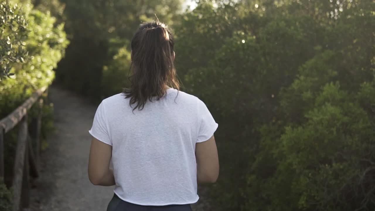 toma en cámara lenta de una joven modelo caminando por un camino de grava en el campo