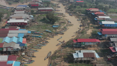 aerial of village on stilts and many boats along tonle sap river