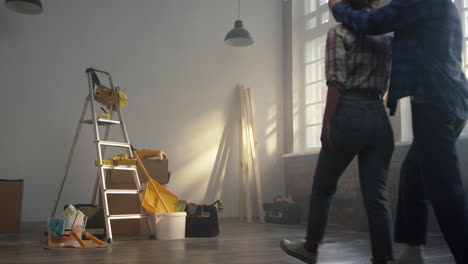 Young-family-rejoicing-in-new-house.-Man-and-woman-enjoying-renovation-indoors.