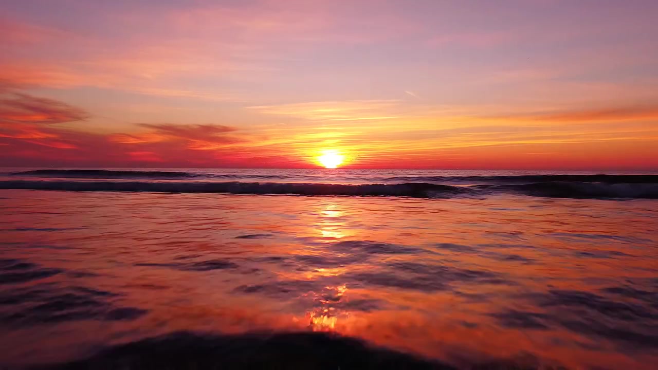 Vibrant Orange Sunset Reflection on Calm Sea Waves