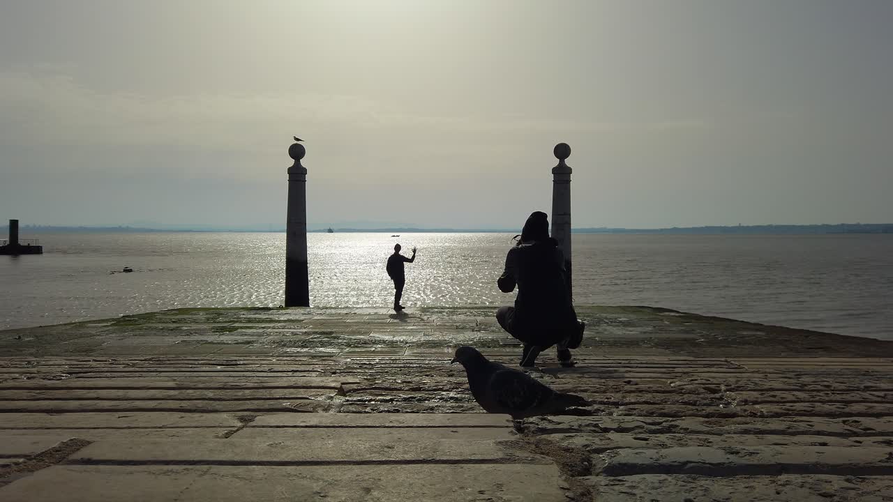 포즈를 취하는 친구의 사진을 찍는 사람, 백그라운드에서 tagus 강, 실루엣 백 뷰, cais das colunas, 리스본, 포르투갈