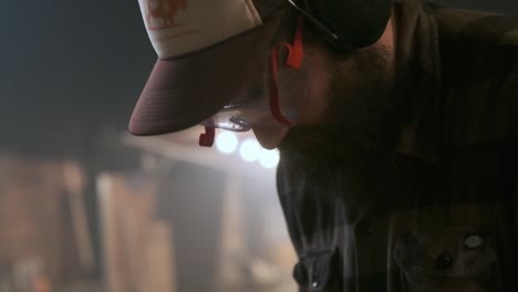 craftsman working with a cutting disc in a moody workshop