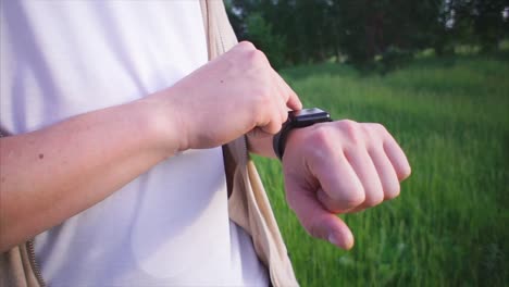 hombre ajustando el reloj inteligente al aire libre