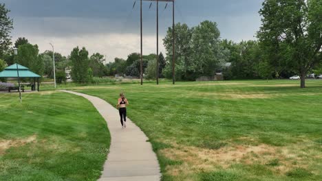 a healthy muscular woman runs along a city pathway inspiring others to get active