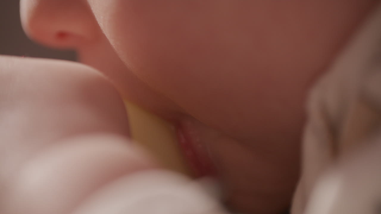Primo piano di un neonato che beve il latte dal biberon durante l'ora della poppata