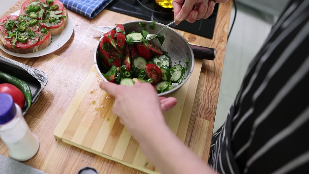 Preparing a fresh salad and tomato sandwiches