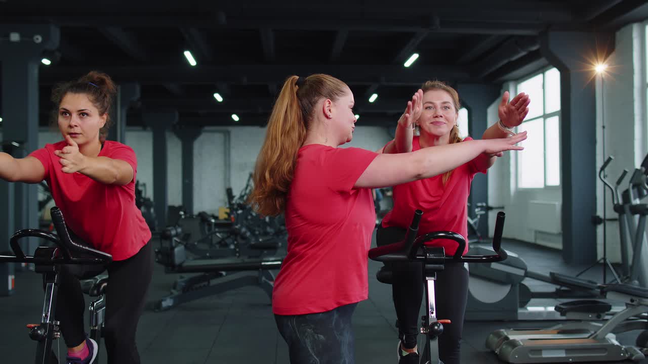 Group of girls performs aerobic training workout cardio routine on bike simulators cycle training