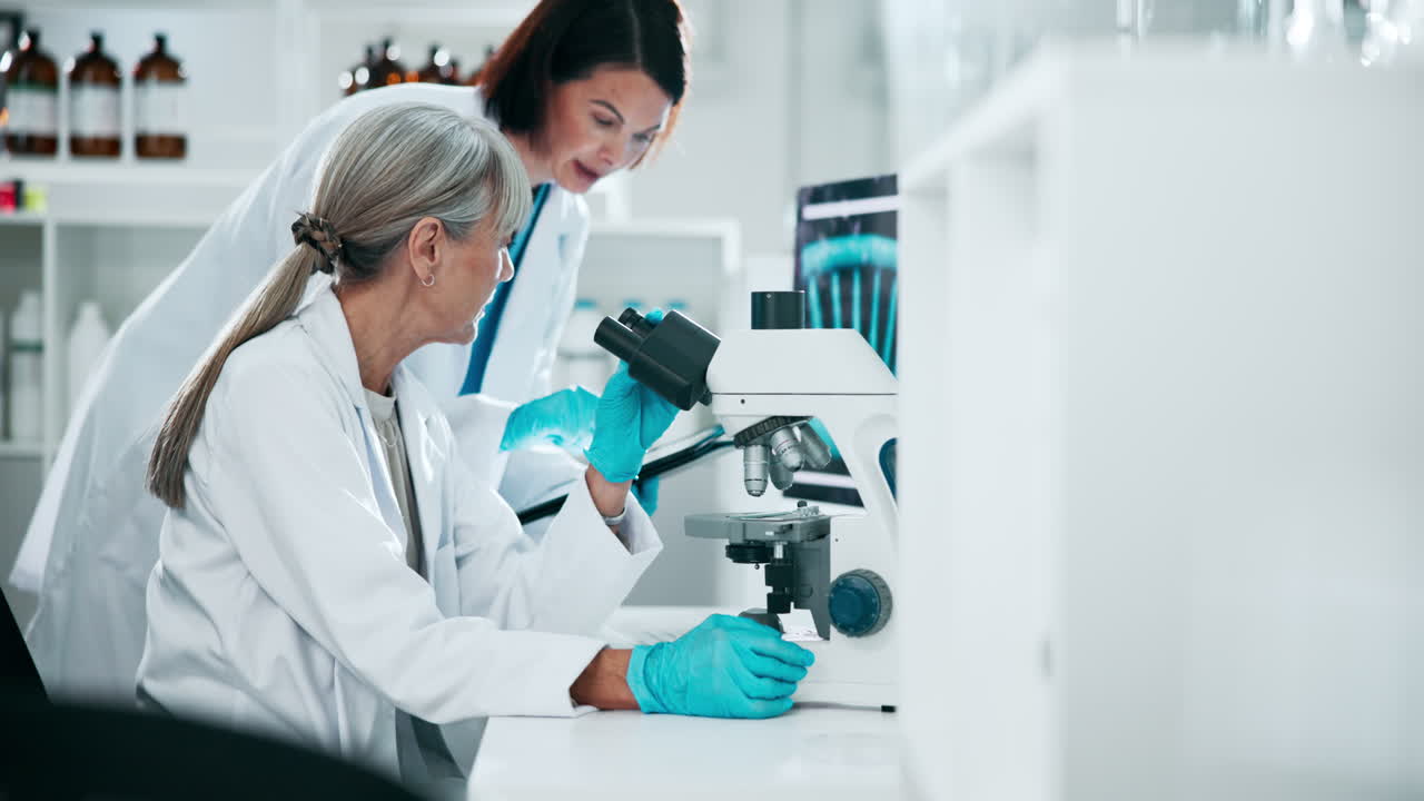 Scientists working with a microscope in a lab