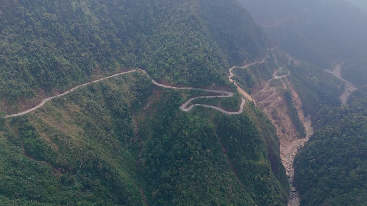 Fly above Ha Giang’s curvy mountain roads surrounded by thick jungle. This aerial footage captures the winding paths through northern Vietnam’s untamed, scenic landscapes.