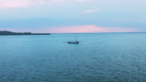 Toma-Panorámica-Lenta-De-Un-Dron-De-Un-Barco-De-Pesca-Solitario-En-Tofo,-Mozambique