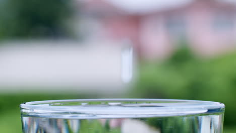 Eine-Nahaufnahme-Von-Wassertropfen,-Die-In-Einem-Glas-Spritzen-Und-Spritzen-Und-Dabei-Wellen-Und-Wellen-Erzeugen