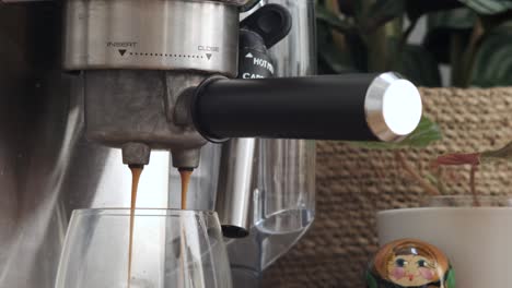 recién elaborado: primer plano de la máquina de espresso vertiendo un golpe rico