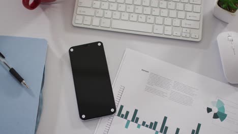 View-of-smartphone-and-office-supplies-on-desk-at-office