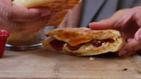 close up of a person making a delicious sandwich with eggs, cheese, and tomato