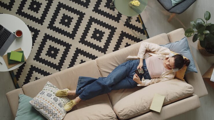 Mujer escuchando música en el teléfono en casa
