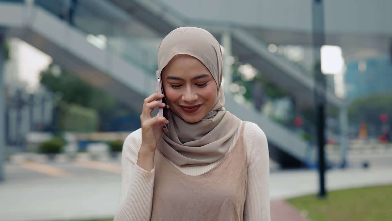 Woman in hijab talking on the phone in urban area