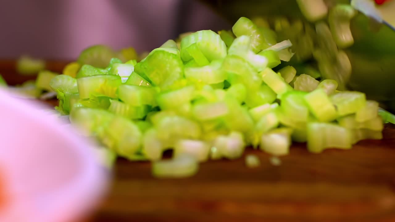 Close-up of cutting celery with a large knife on a kitchen counter