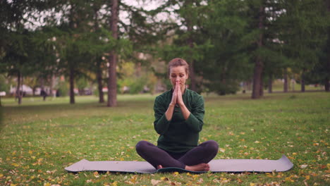 mujer practicando yoga en un parque