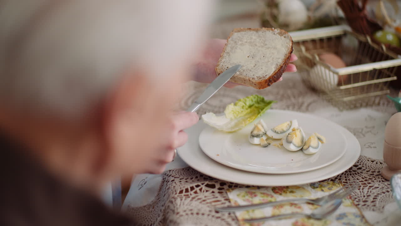 Close-up of Hands Spreading Butter on a Slice of Bread