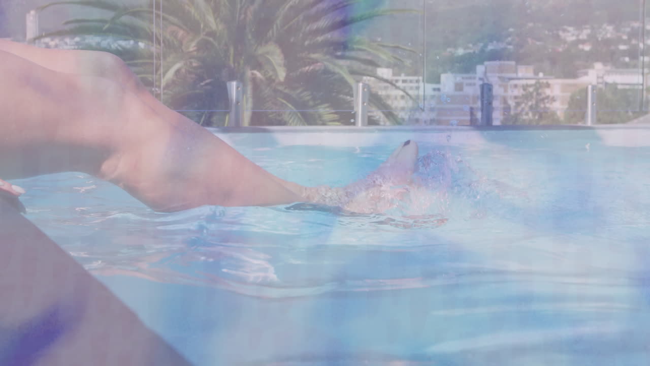 Relaxing in rooftop pool, person with cityscape and palm tree view