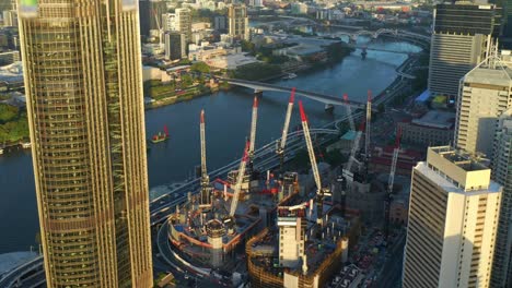 construction progress of queen's wharf at the embankment of brisbane river with view of victoria bridge at sunset in brisbane queensland