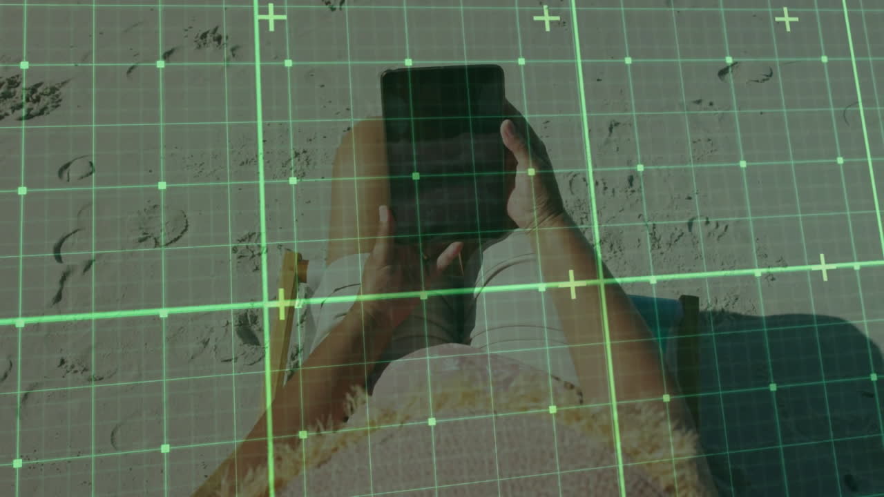Person using tablet on beach with digital grid overlay animation