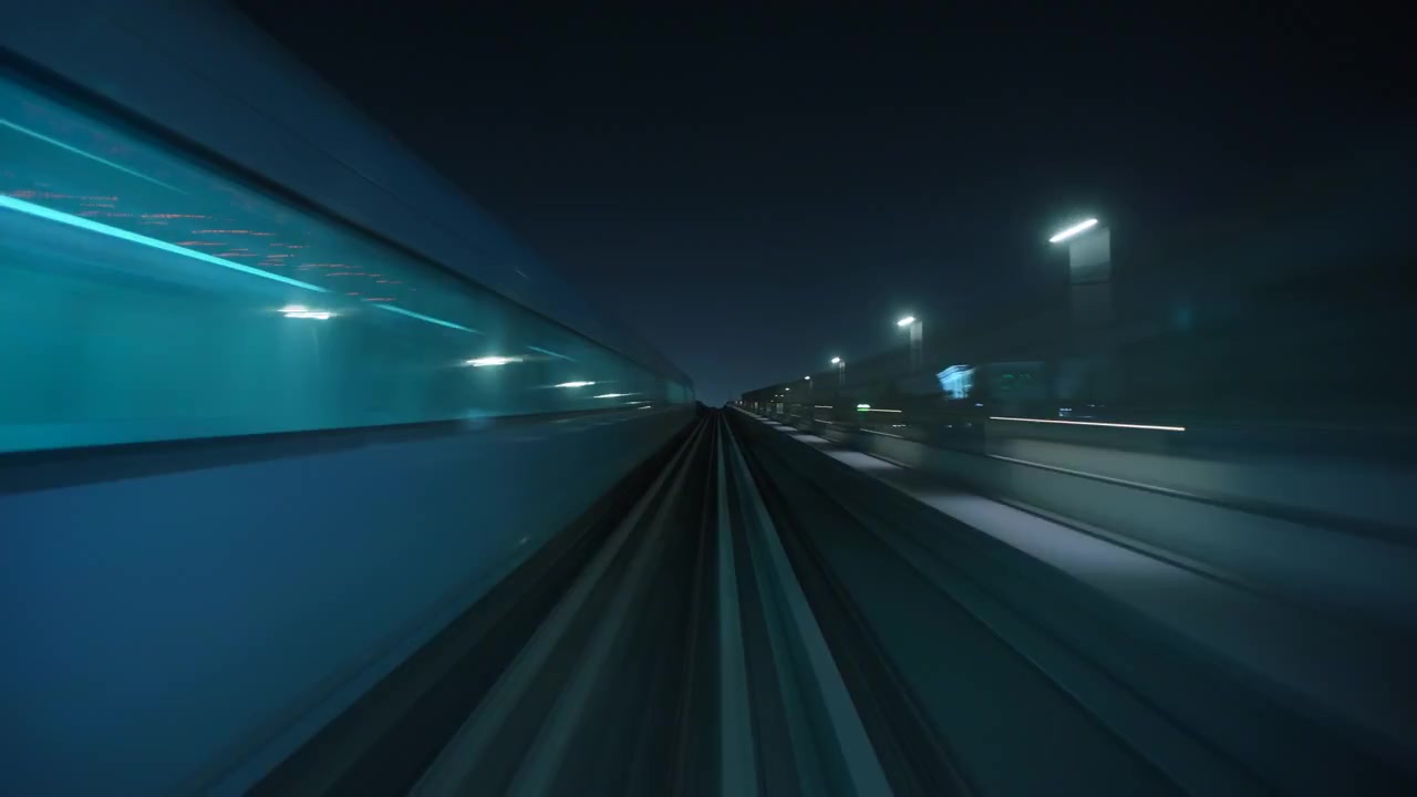 Vista notturna dal finestrino anteriore di un treno in movimento.