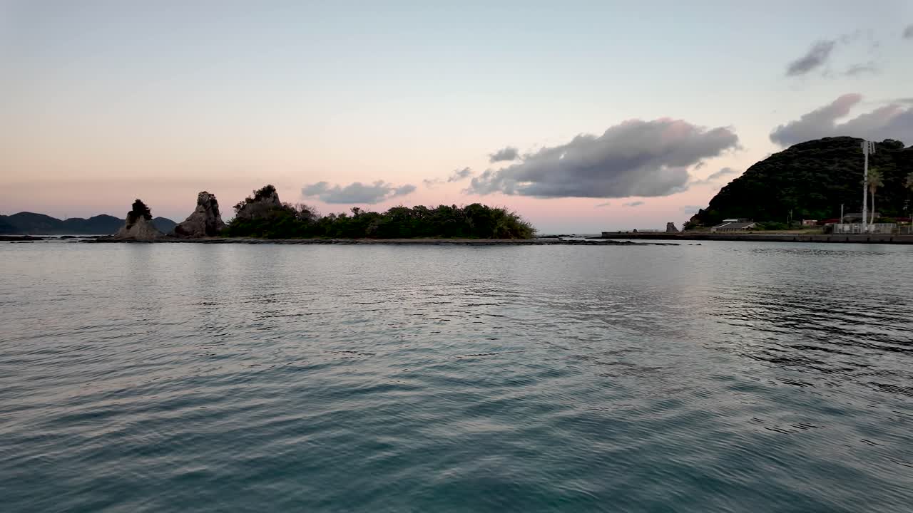 Scenic view of golden hour over Nachi Bay with picturesque islands and tranquil water. Panning Shot
