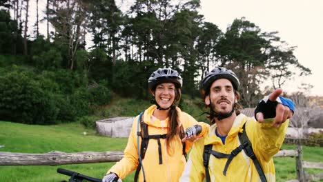 Mountain-biking-couple-pointing-at-nature