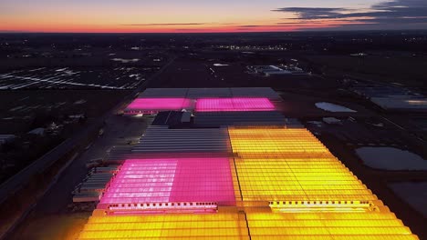 aerial view of glowing greenhouses at night in carlton, michigan, usa