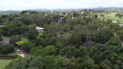 vista aérea de un gran parque verde con una pequeña vista de la ciudad en el fondo