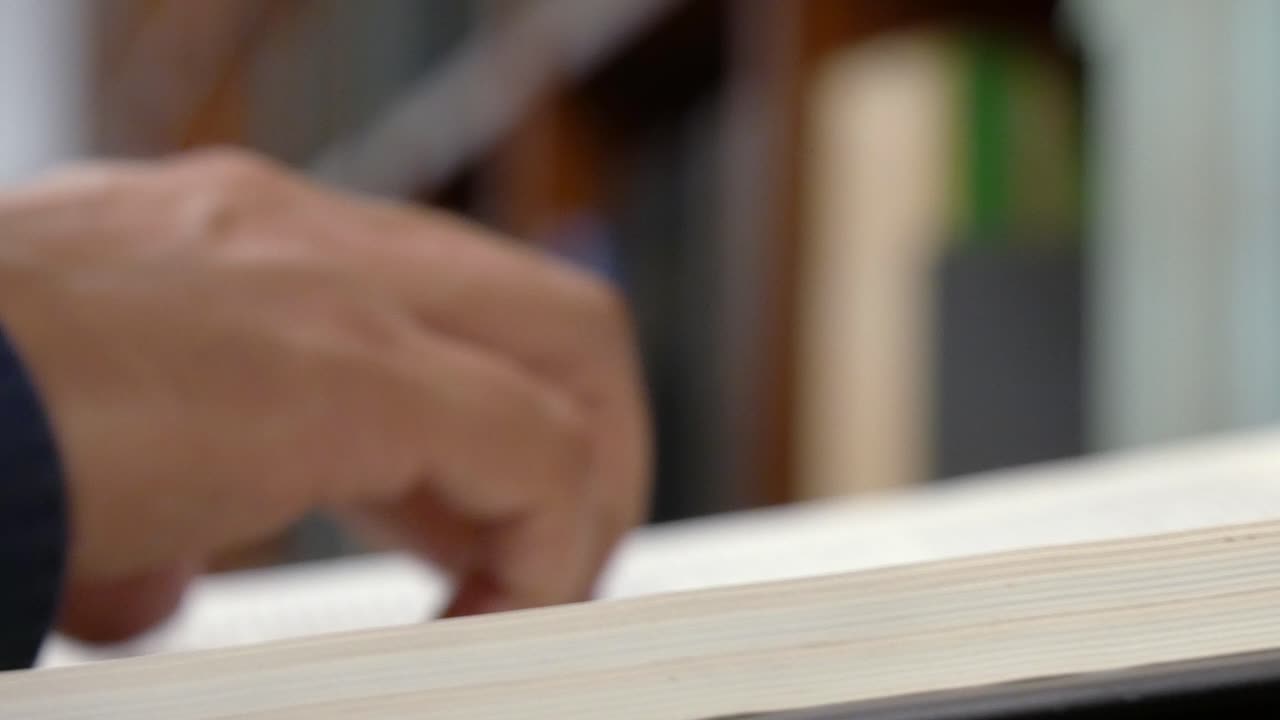 vista lateral de primer plano de una persona que pasa las páginas de un libro