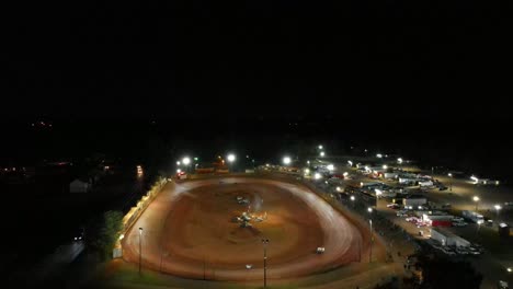 aerial still footage of car racing on oval dirt track