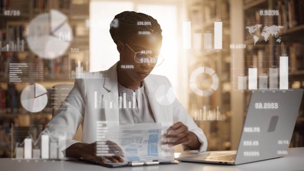 Focused Professional Woman Analyzing Data in a Library Setting, Taking Notes and Using a Laptop for Research and Visualization of Statistical Information