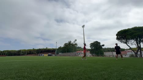 People playing rugby on a green field