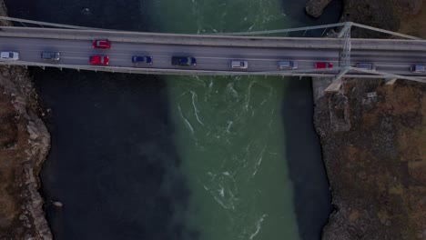 vehicles driving across olfusarbru bridge over olfusa river running through selfoss town and fields in iceland