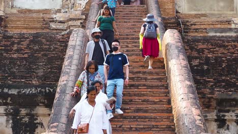 los turistas suben las escaleras del antiguo templo en ayutthaya