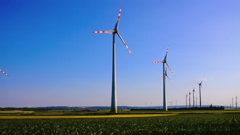 Wind turbines generating clean energy. Wind turbines rise against a clear blue sky, showcasing sustainable energy in a rural setting