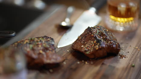 herb crusted steak sitting on a walnut cutting board