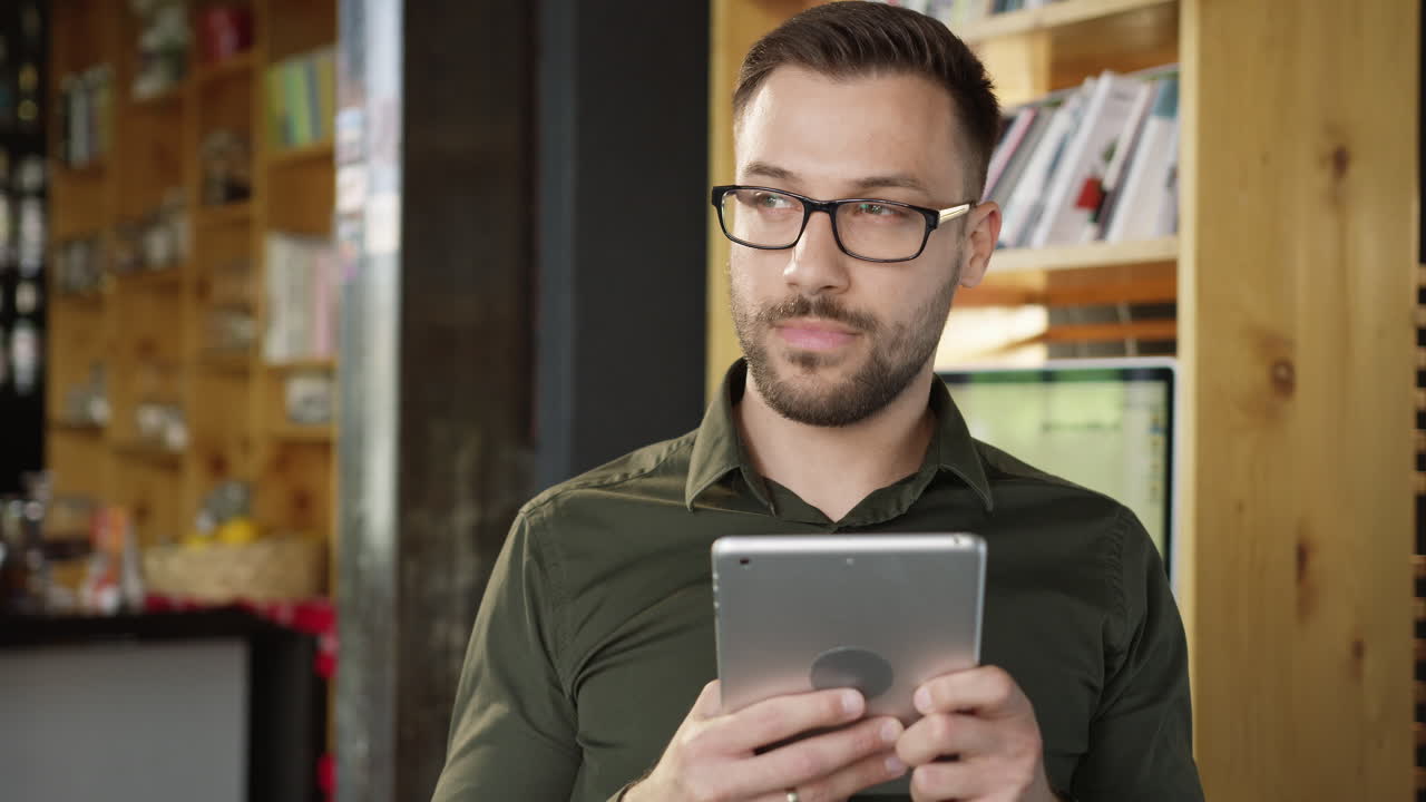Hombre usando tableta en cafetería