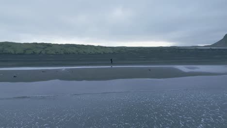 person walking at stokksnes beach in iceland