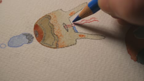 la mano sosteniendo un lápiz de color y dibujando formas abstractas coloridas, de cerca
