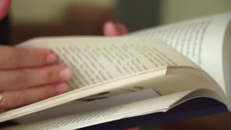 close-up view of hands gently flipping through a book, capturing a calm and mindful reading session