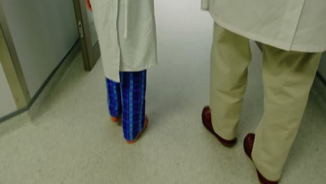 Doctor-walking-with-patient-in-hospital-corridor